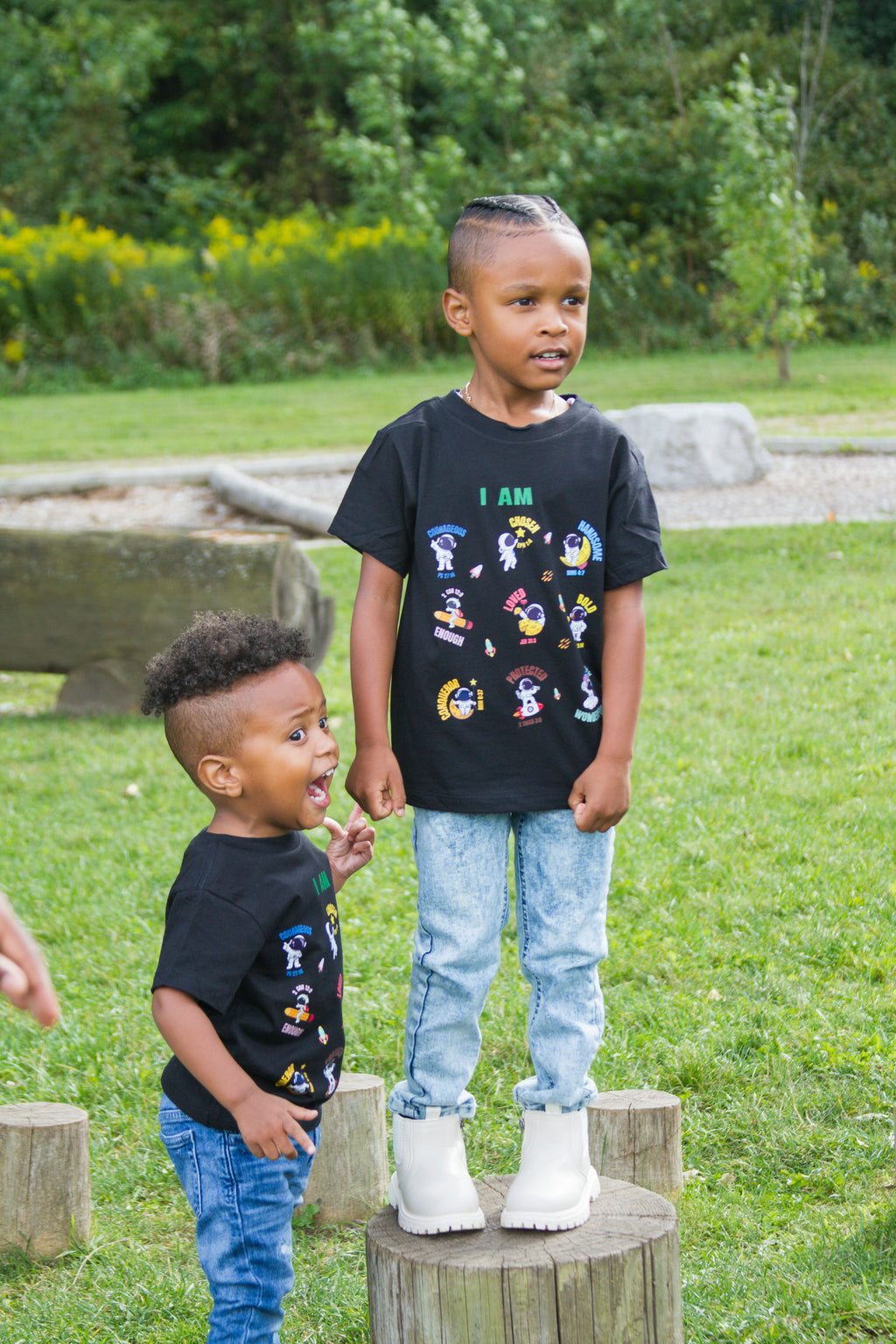 Two boys wearing black t-shirt with multiple images of astronaut with "I AM" words of affirmation.